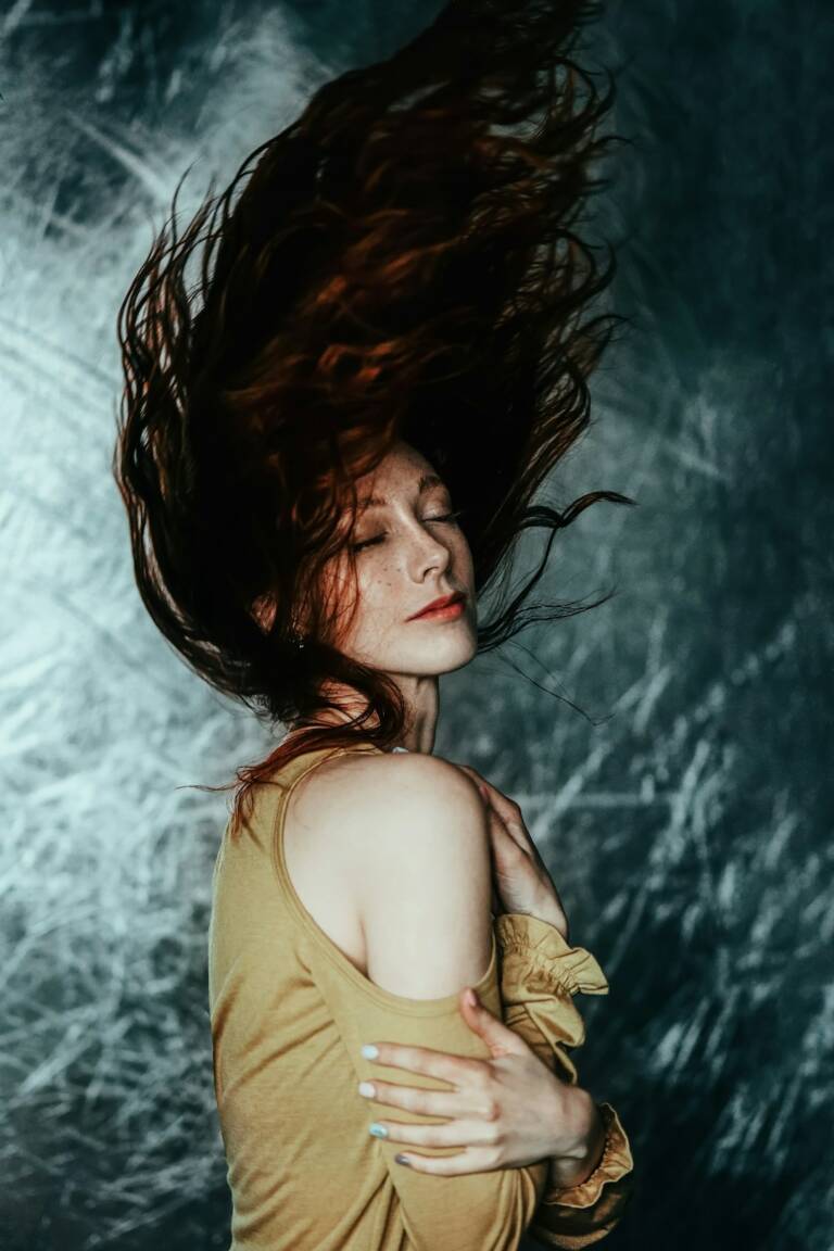 Mulher de cabelos longos avermelhados em movimento, fotografia editorial ilustrativa