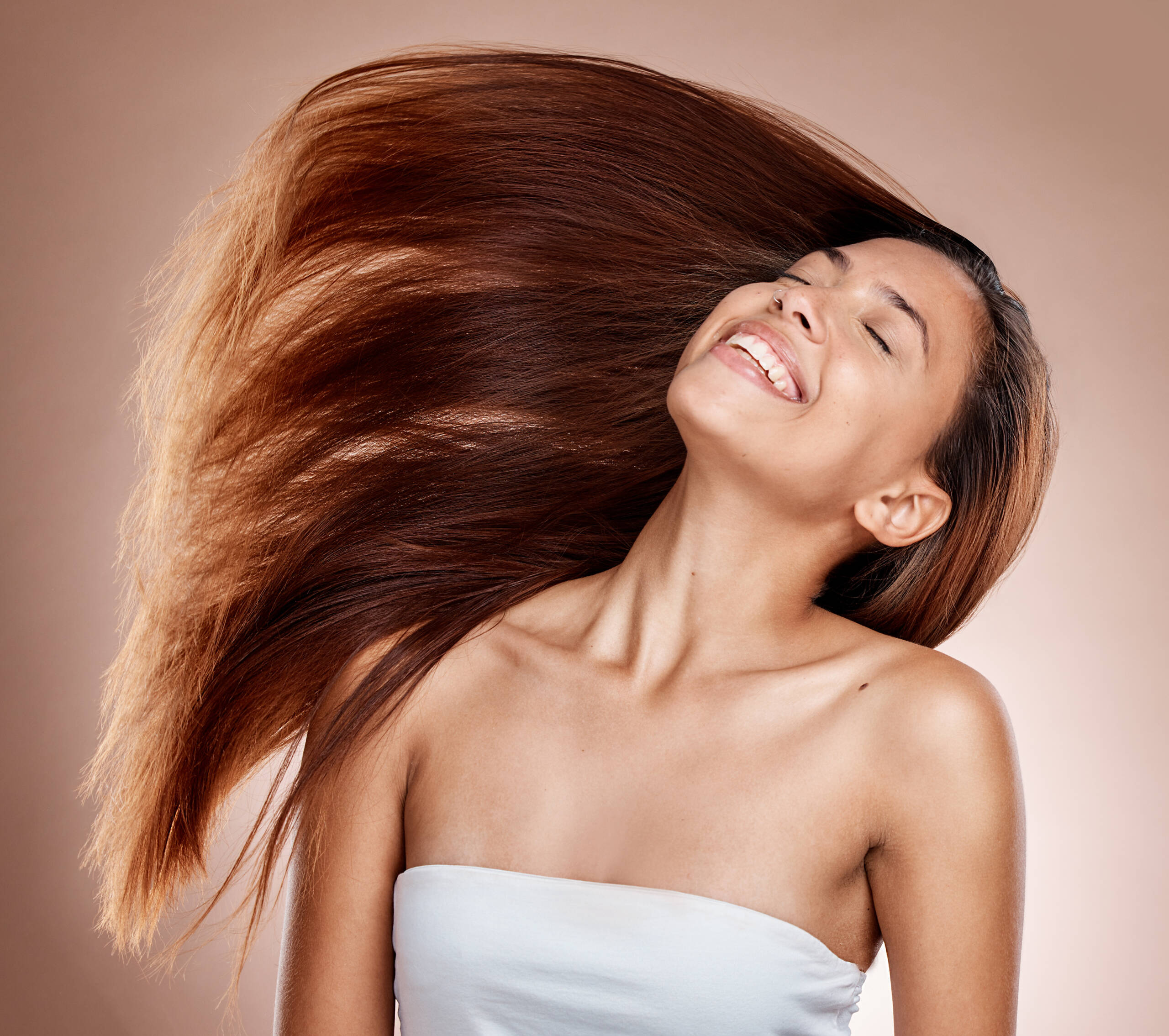 Mulher sorrindo com cabelo castanho longo e liso em movimento